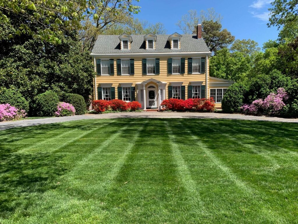 Federalist-style house with a freshly mowed and maintained lawn in the foreground