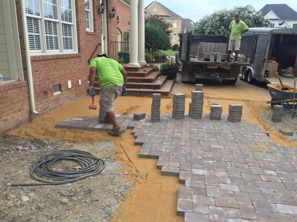 Green Side Up crews laying bricks for a paver patio