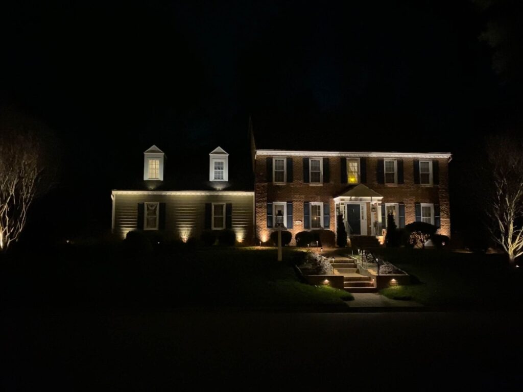 Nighttime photo of a house with landscape lighting in Virginia