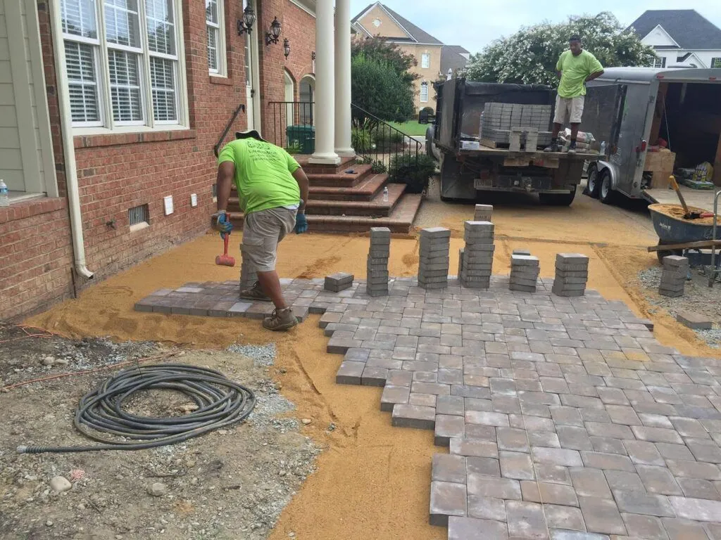 Green Side Up crews laying bricks for a paver patio
