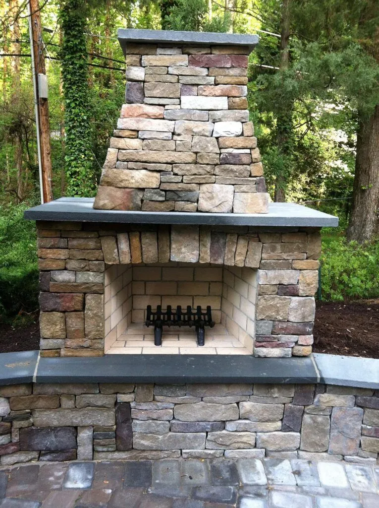 Outdoor fireplace in a wooded area for GSU's hardscaping portfolio