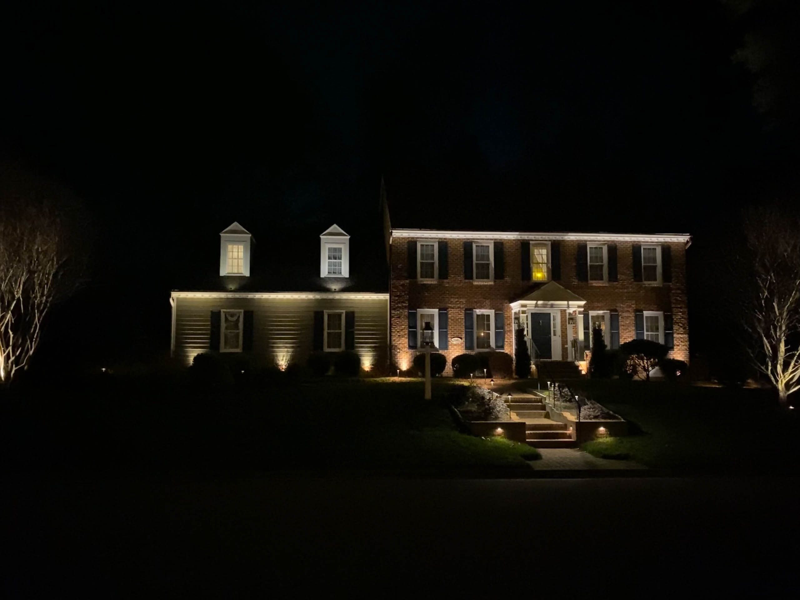 Nighttime photo of a house with landscape lighting in Virginia